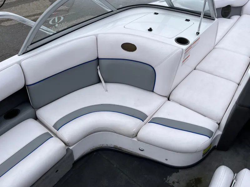 Slide: The Image of 2004 Supra Launch boat interior with white and gray seating, cup holder, and windshield. - 14