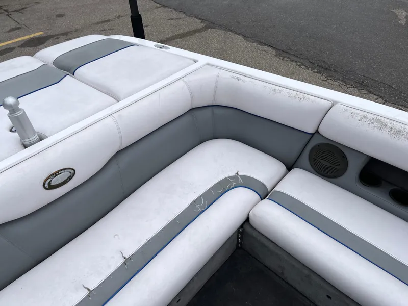 Slide: The Image of 2004 Supra Launch boat interior with white and gray seating, showing wear and speaker detail. - 16
