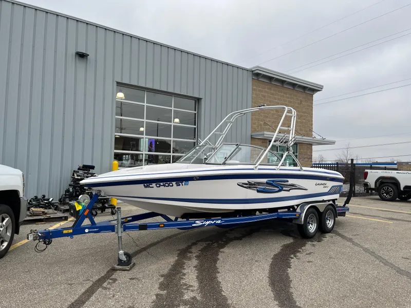 Slide: The Image of 2004 Supra Launch boat on trailer outside a building, ready for transport. - 2