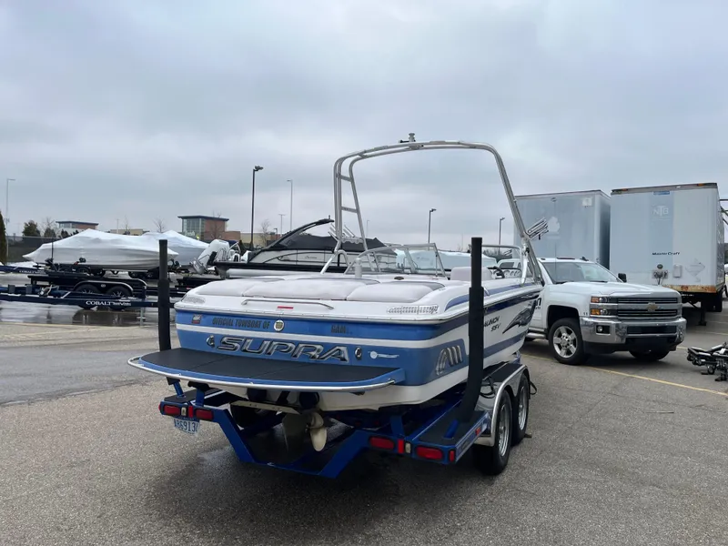 Slide: The Image of 2004 Supra Launch boat on trailer in parking lot, overcast sky. - 5