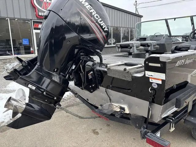 Slide: The Image of 2015 Lund Impact 1875 SS boat with Mercury outboard motor, parked outside a dealership. - 3