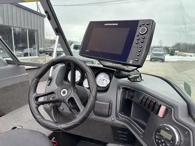 Slide: The Image of 2015 Lund Impact 1875 SS boat dashboard with steering wheel and Humminbird fishfinder. - 7