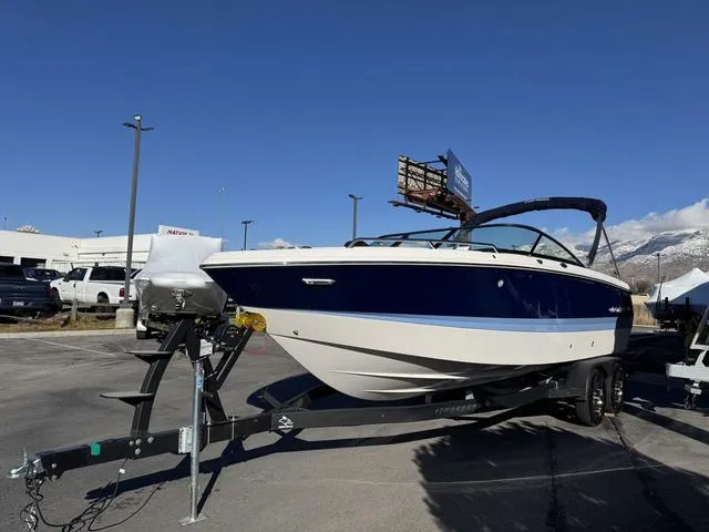 Slide: The Image of 2024 Chaparral 247 SSX boat on trailer, parked outdoors under clear blue sky. - 3