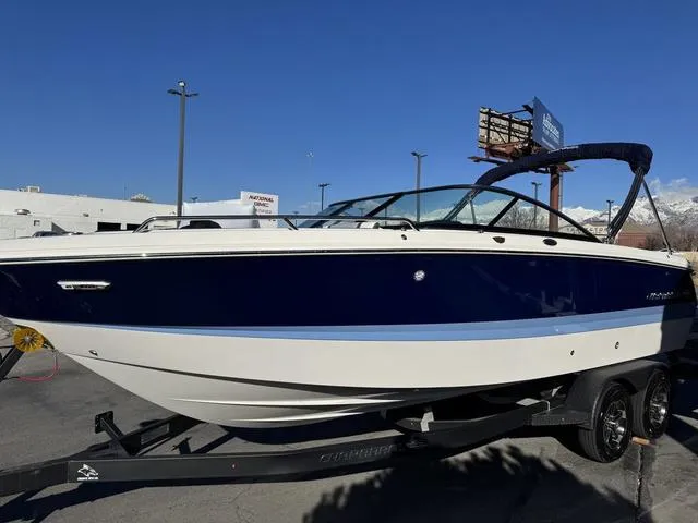Slide: The Image of 2024 Chaparral 247 SSX boat on trailer, blue and white design, parked outdoors. - 4