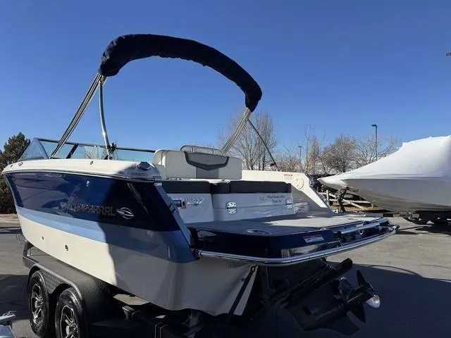 Slide: The Image of 2024 Chaparral 247 SSX boat with blue and white exterior, parked on a trailer. - 5