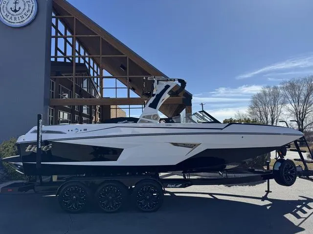 Slide: The Image of 2025 Tigé 24RZX boat on trailer, parked outside a modern building. - 15