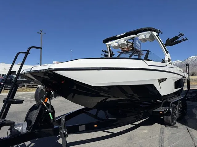 Slide: The Image of 2025 Tigé 24RZX boat on trailer, sleek design, parked outdoors under clear blue sky. - 3