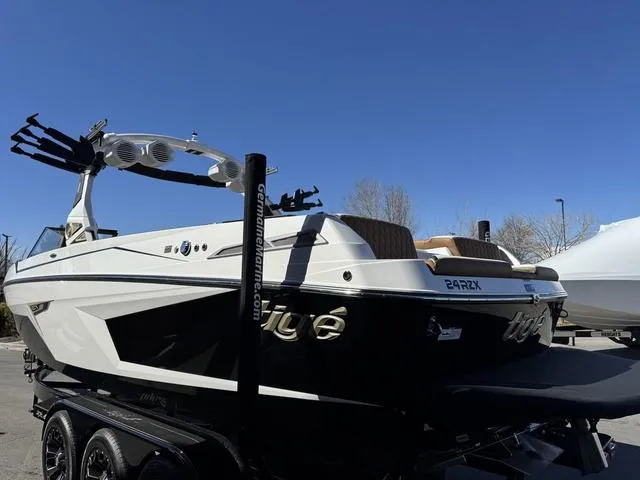 Slide: The Image of 2025 Tigé 24RZX boat on trailer under clear blue sky. - 4