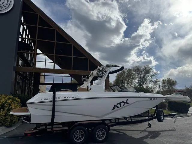 Slide: The Image of 2023 ATX Boats 22 TYPE-S on trailer, parked outside modern building under cloudy sky. - 8