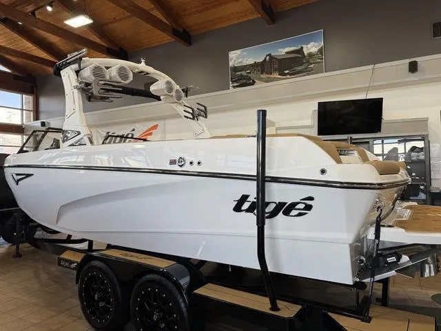 Slide: The Image of 2025 Tigé Z3 boat in showroom, white exterior, on trailer, modern design. - 2