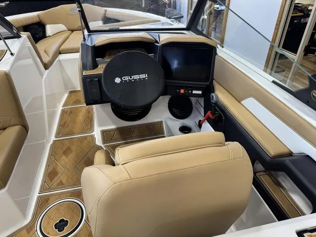 Slide: The Image of 2025 Tigé Z3 boat interior with tan seating, modern dashboard, and Gussi steering wheel. - 6
