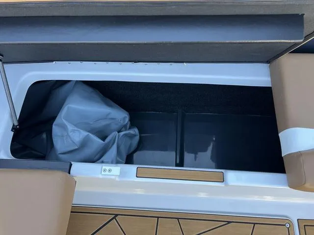 Slide: The Image of 2024 ATX Boats 24 TYPE-S storage compartment with brown seating and interior cover. - 14