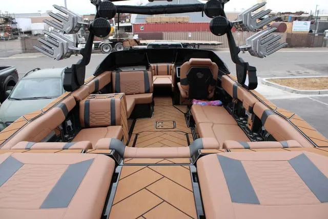 Slide: The Image of 2024 Malibu 26 LSV boat seat with tan upholstery and cup holders. - 5