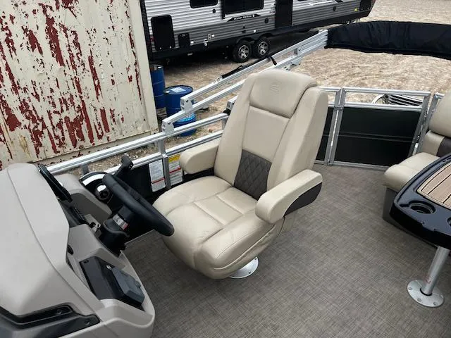 Slide: The Image of 2024 Sun Tracker 20PB pontoon boat interior with beige captain's chair and steering console. - 12