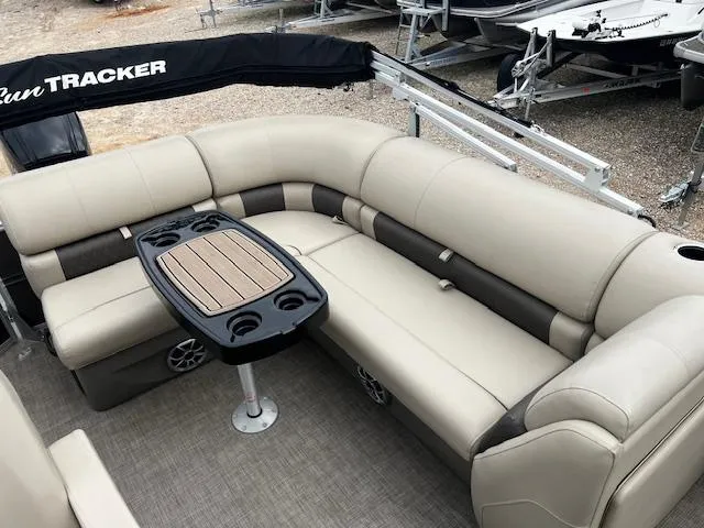 Slide: The Image of 2024 Sun Tracker 20PB pontoon boat interior with beige seating and a central table. - 13