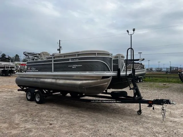 Slide: The Image of 2024 Sun Tracker 20PB pontoon boat on trailer in outdoor setting. - 4