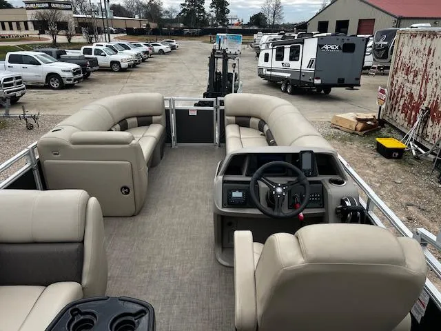 Slide: The Image of 2024 Sun Tracker 20PB pontoon boat with beige seating and modern dashboard, parked in a lot. - 7