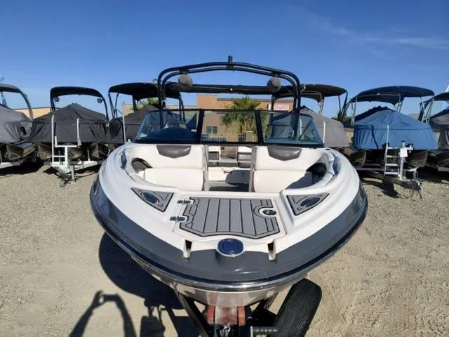 Slide: The Image of 2016 Chaparral Vortex 223 VRX boat, front view, parked on gravel lot under clear blue sky. - 6
