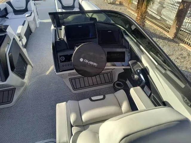 Slide: The Image of 2025 Avalon Excalibur Quad Lounge Windshield 27 FT boat interior with modern dashboard and seating. - 13