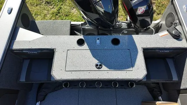 Slide: The Image of 2025 Lund 2075 Fisherman Sport boat interior with storage compartments and dual engines. - 16