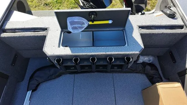 Slide: The Image of 2025 Lund 2075 Fisherman Sport boat interior with rod holders and storage compartment. - 17