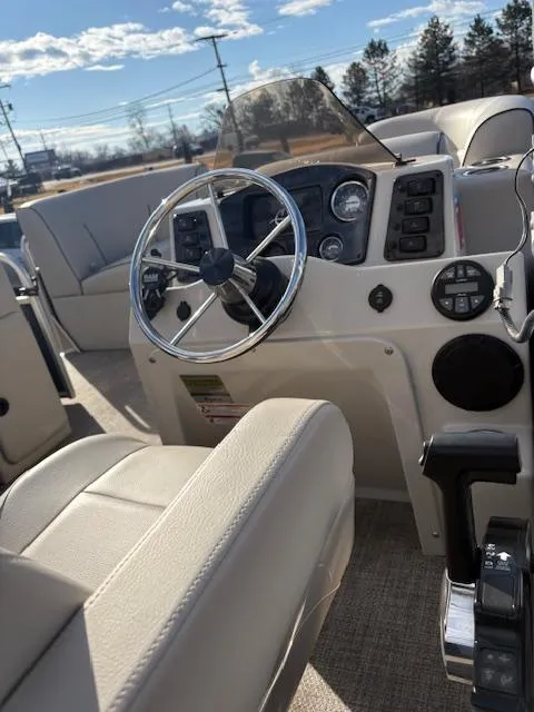 Slide: The Image of 2021 Quest le816 boat interior with steering wheel and control panel under sunny skies. - 3