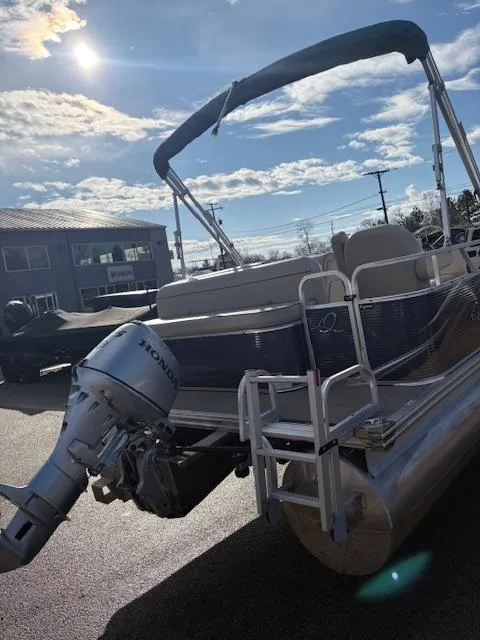 Slide: The Image of 2021 Quest le816 pontoon boat with Honda outboard motor, parked outdoors under a sunny sky. - 7