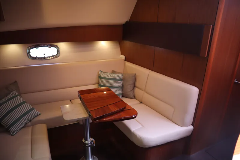 Slide: The Image of Interior of 2016 Tiara Yachts 4300 Open with cozy seating and wooden table. - 11