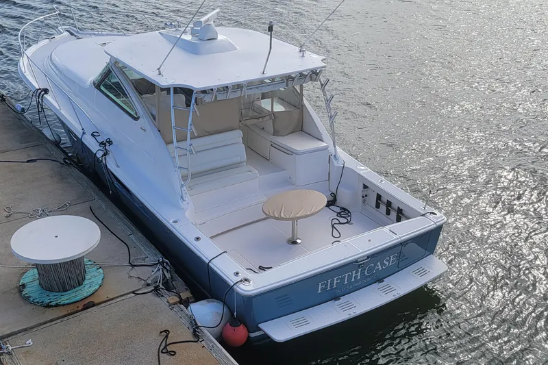 Slide: The Image of 2016 Tiara Yachts 4300 Open docked, rear view, with spacious deck and seating area. - 2
