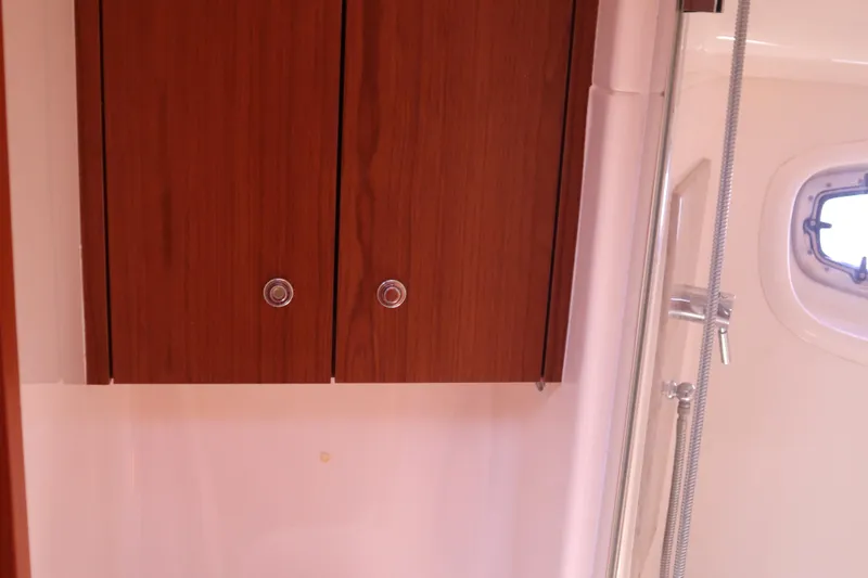 Slide: The Image of Interior of 2016 Tiara Yachts 4300 Open, featuring wooden cabinets and a shower area. - 24
