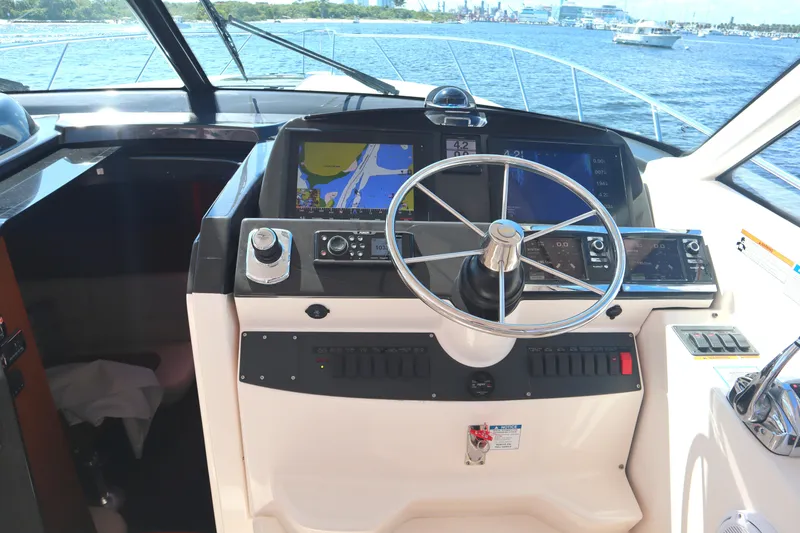 Slide: The Image of 2016 Tiara Yachts 4300 Open helm with navigation screens and steering wheel. - 28