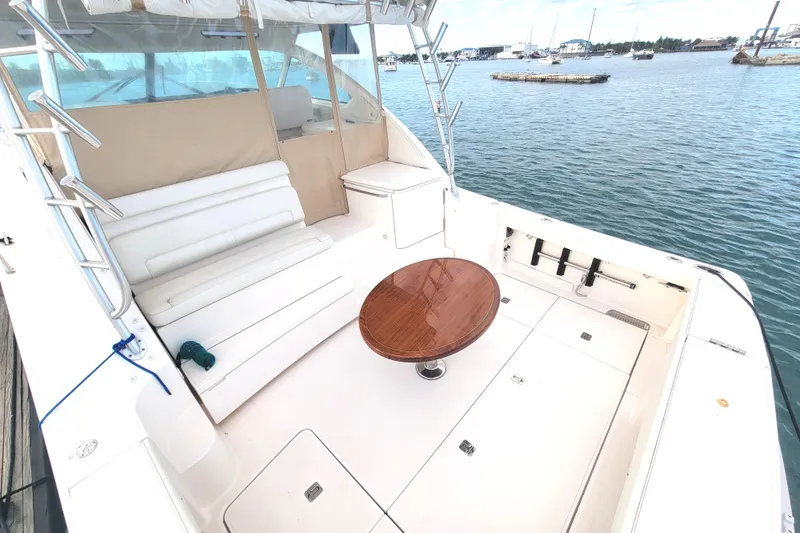 Slide: The Image of 2016 Tiara Yachts 4300 Open cockpit with seating and table, docked by the water. - 35