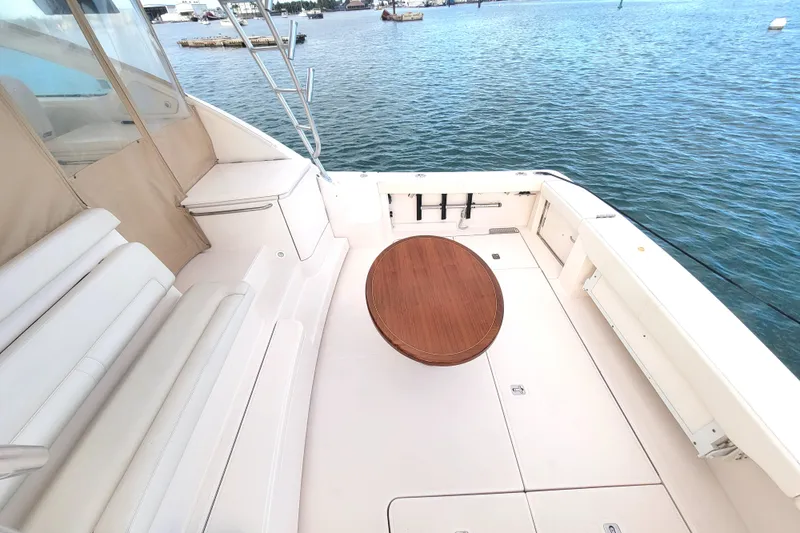 Slide: The Image of 2016 Tiara Yachts 4300 Open deck with seating and wooden table, overlooking water. - 37
