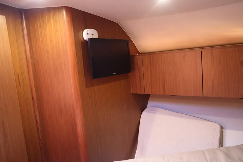 Slide: The Image of Interior of 2016 Tiara Yachts 4300 Open with wood paneling and mounted TV. - 4