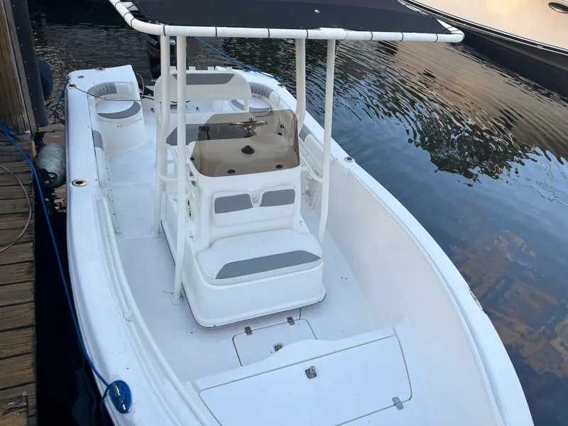 Slide: The Image of 2019 Polar 195CC boat docked on calm water, featuring a center console and canopy. - 2