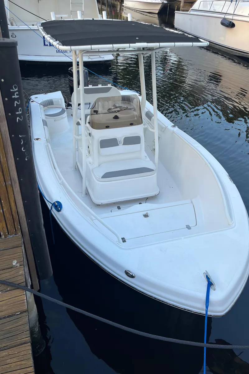 Slide: The Image of 2019 Polar 195CC boat docked in marina, featuring a sleek white design and canopy. - 3