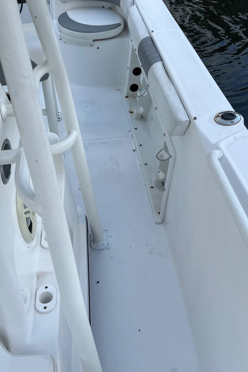 Slide: The Image of 2019 Polar 195CC boat interior, white deck, rod holders, and seating near water. - 7
