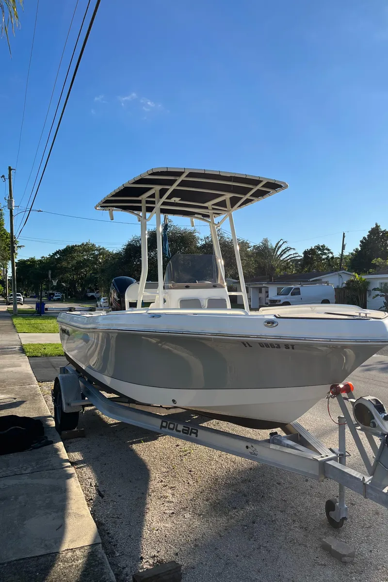 Slide: The Image of 2019 Polar 195CC boat on trailer, parked on a sunny residential street. - 10