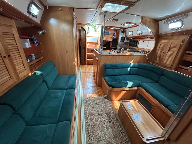Slide: The Image of Interior of 1994 Freedom 45 Aft Cockpit sailboat with green seating and wooden finishes. - 13