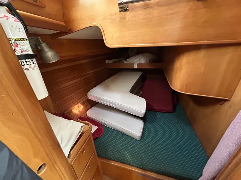 Slide: The Image of 1994 Freedom 45 Aft Cockpit interior cabin with wooden finish and stacked cushions. - 21