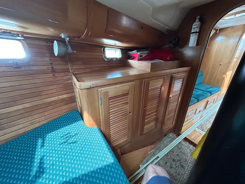 Slide: The Image of Interior of 1994 Freedom 45 Aft Cockpit sailboat with wooden cabinetry and blue seating. - 24
