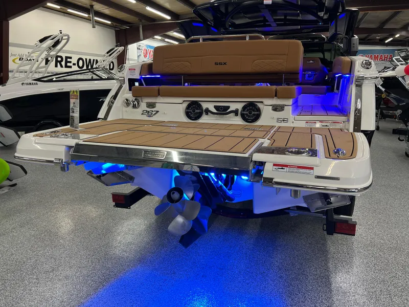 Slide: The Image of 2025 Chaparral 267 SSX boat with illuminated swim platform and sleek design in showroom. - 10