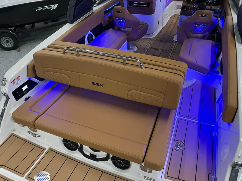 Slide: The Image of 2025 Chaparral 267 SSX boat interior with tan seating and blue LED lighting. - 13