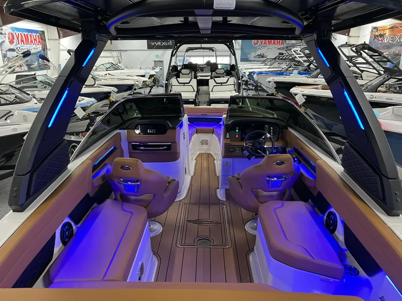 Slide: The Image of 2025 Chaparral 267 SSX boat interior with modern seating and ambient blue lighting. - 17