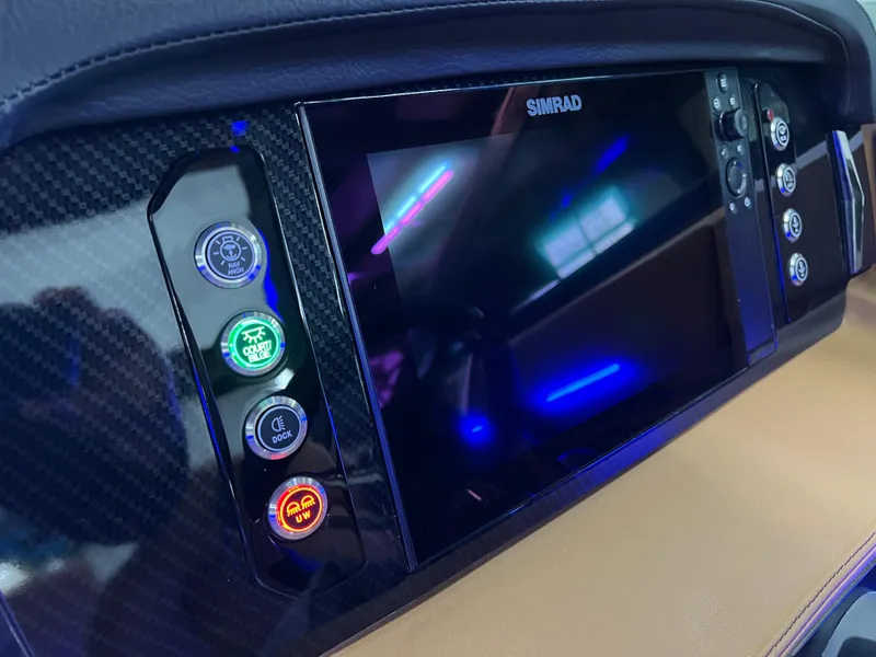 Slide: The Image of 2025 Chaparral 267 SSX dashboard with Simrad display and illuminated control buttons. - 25