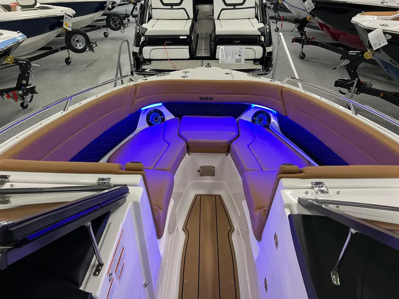 Slide: The Image of 2025 Chaparral 267 SSX boat interior with blue LED lighting and tan seating. - 28