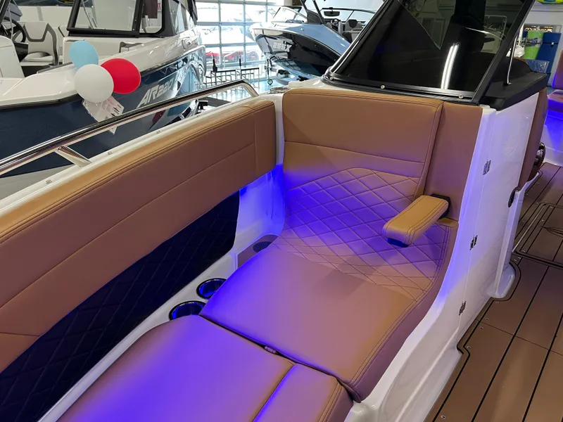 Slide: The Image of 2025 Chaparral 267 SSX boat interior with tan seating and blue LED lighting. - 29