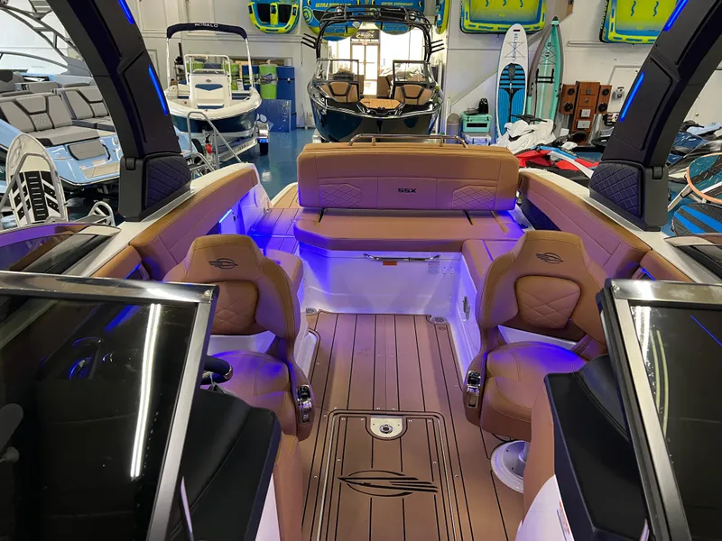 Slide: The Image of 2025 Chaparral 267 SSX boat interior with luxurious seating and ambient lighting in showroom. - 32