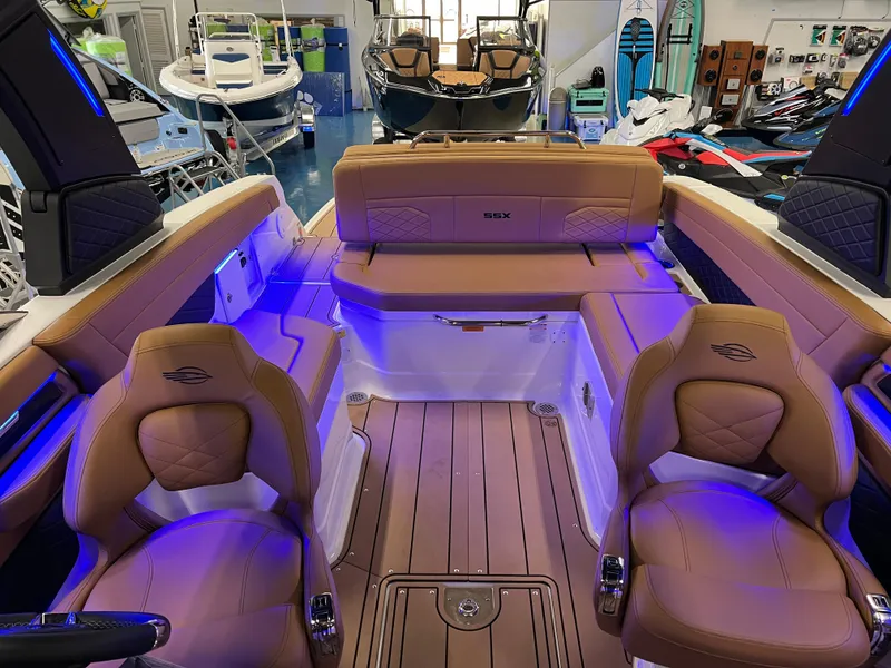 Slide: The Image of 2025 Chaparral 267 SSX boat interior with tan seating and blue accent lighting. - 33
