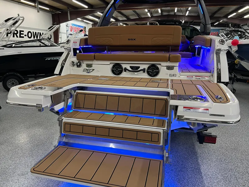 Slide: The Image of 2025 Chaparral 267 SSX boat with illuminated deck and seating in showroom. - 6